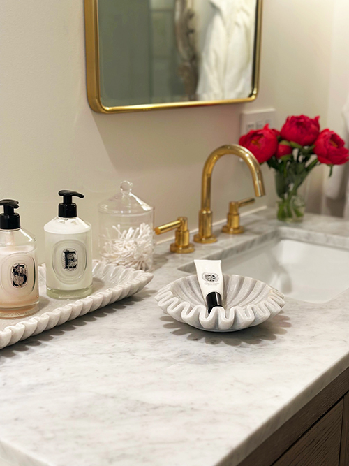 Bathroom counter styled with roses and ceramic details