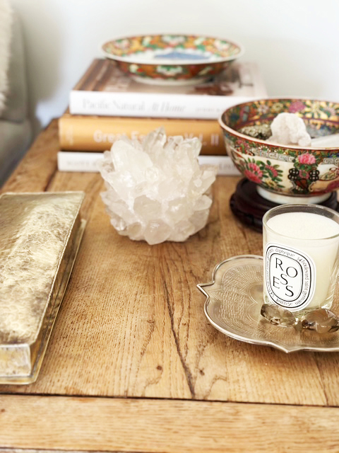 Layered books, ceramics and candle on a wood table
